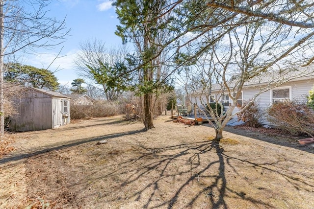 view of yard with a wooden deck, a storage shed, and an outdoor structure