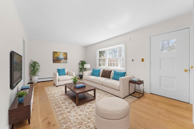 living room with a baseboard heating unit and light wood-type flooring