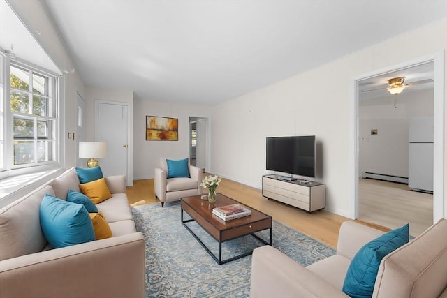 living room featuring baseboards, light wood-type flooring, and baseboard heating