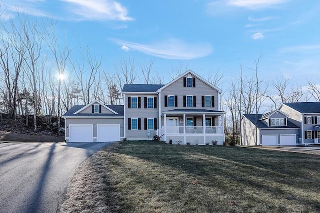 view of front of property with a porch, a garage, and a front lawn