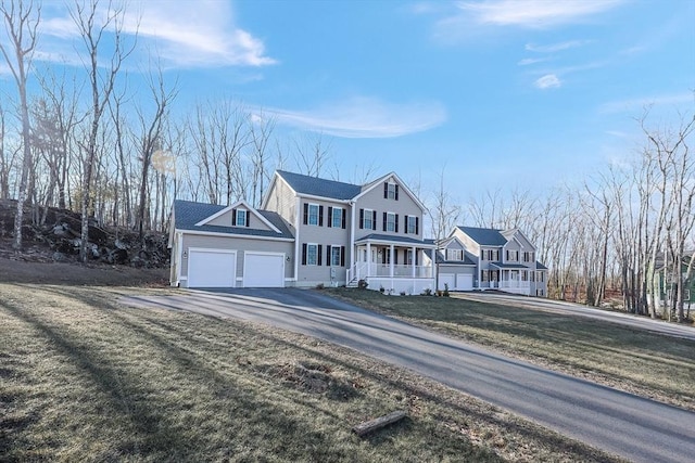 view of front of home with a garage, covered porch, and a front yard