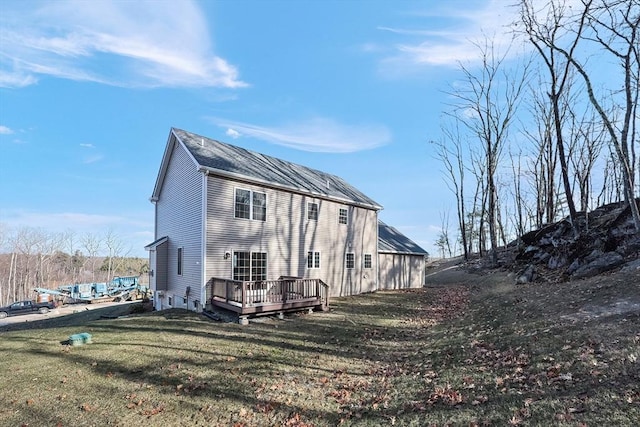 back of property featuring a yard and a wooden deck