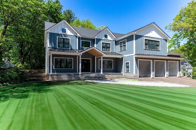 modern inspired farmhouse featuring a standing seam roof, metal roof, an attached garage, a porch, and driveway