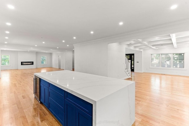 kitchen featuring open floor plan, recessed lighting, a kitchen island, light wood-type flooring, and coffered ceiling