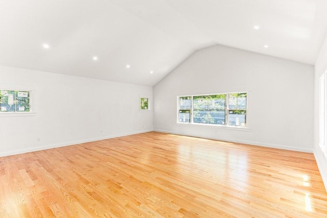 empty room featuring healthy amount of natural light, light wood-style flooring, vaulted ceiling, and recessed lighting
