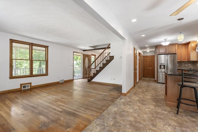 25 Hamilton Rd, Northborough, MA 01532 - kitchen featuring stainless steel fridge, dark countertops, a kitchen bar, brown cabinetry, and recessed lighting