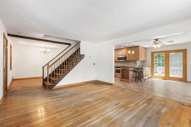 25 Hamilton Rd, Northborough, MA 01532 - unfurnished living room with light wood-type flooring, stairs, a chandelier, and ceiling fan