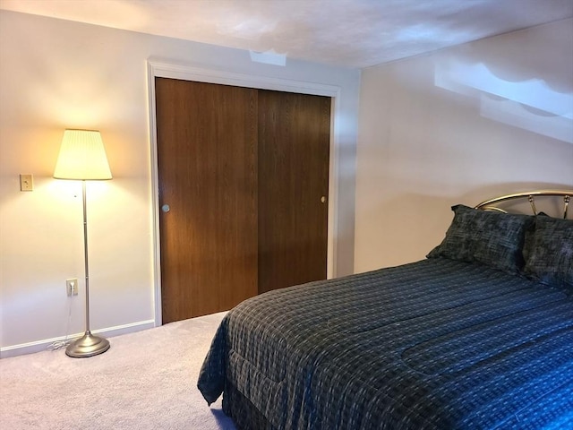 bedroom featuring a closet, baseboards, and carpet