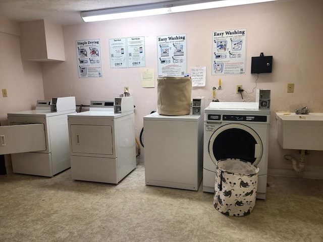 common laundry area with independent washer and dryer, light floors, and a sink