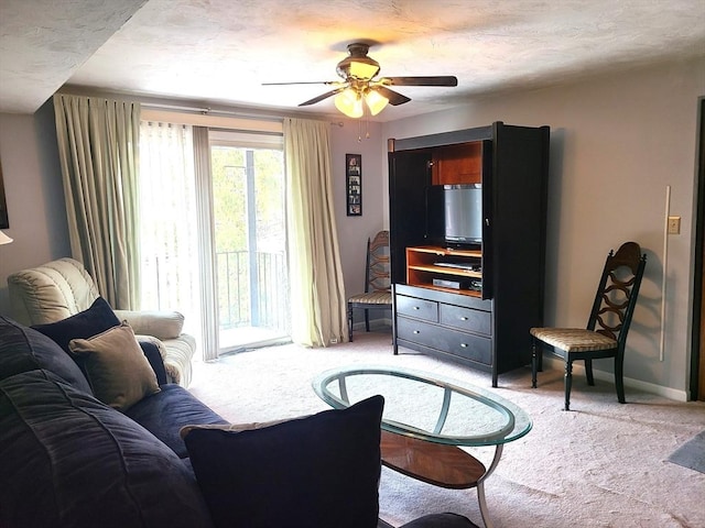 living room with a textured ceiling, a ceiling fan, baseboards, and carpet floors