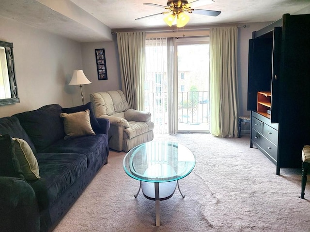 living area with a ceiling fan and carpet flooring