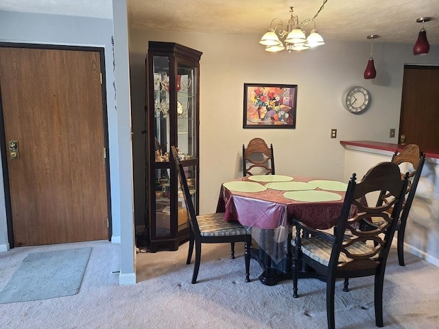 dining space with an inviting chandelier, carpet flooring, and baseboards