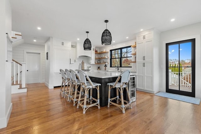 dining space with light wood-type flooring and wet bar