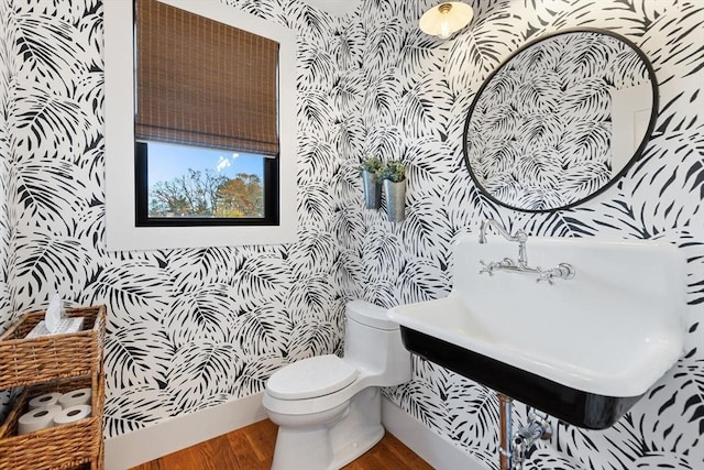 bathroom with toilet, wood-type flooring, and sink