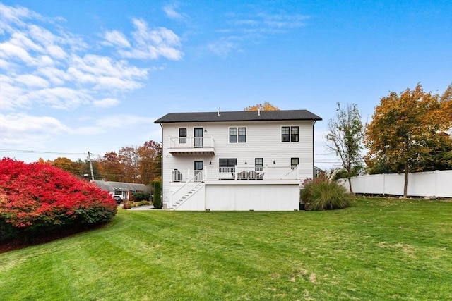 back of property featuring a wooden deck and a yard