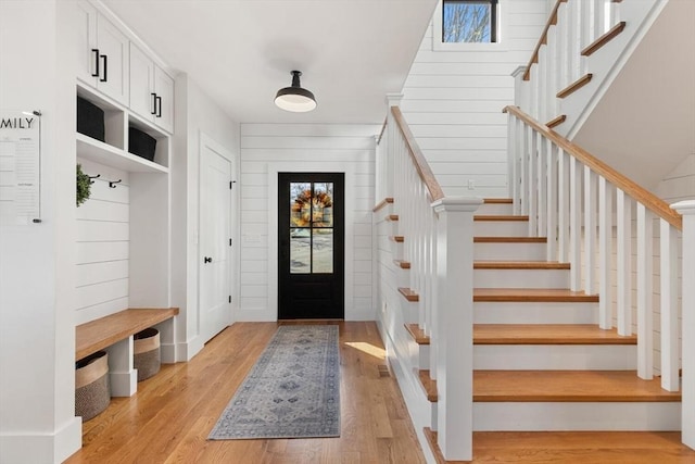 mudroom featuring light hardwood / wood-style flooring and wooden walls