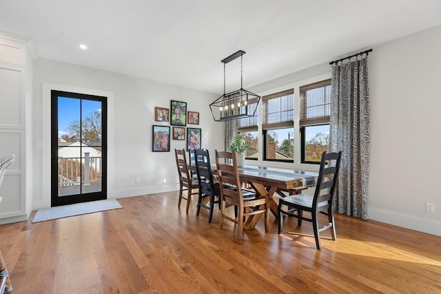 dining space with a notable chandelier and light hardwood / wood-style flooring