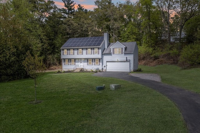 18 Candlewood Dr, Medway, MA 02053 - view of front of property with driveway, solar panels, a front yard, and a chimney