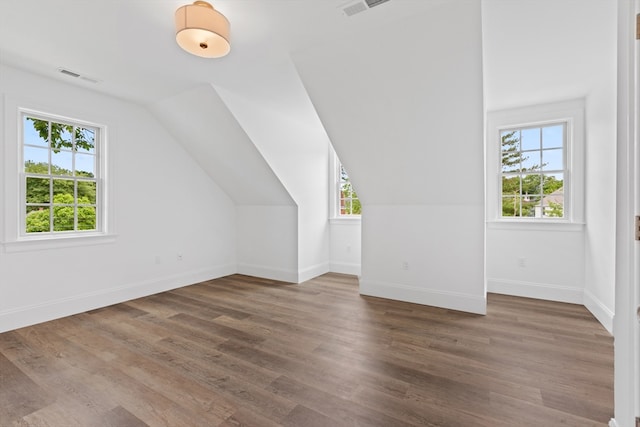 bonus room with dark wood-type flooring and lofted ceiling