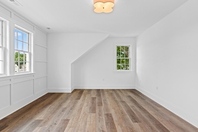 bonus room with a wealth of natural light and light hardwood / wood-style flooring