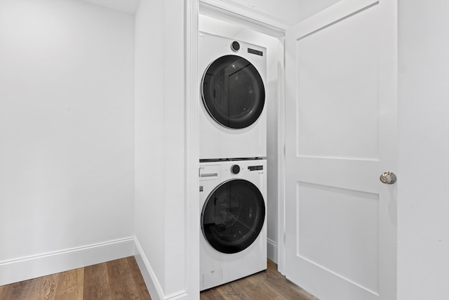 laundry room featuring wood-type flooring and stacked washer and clothes dryer