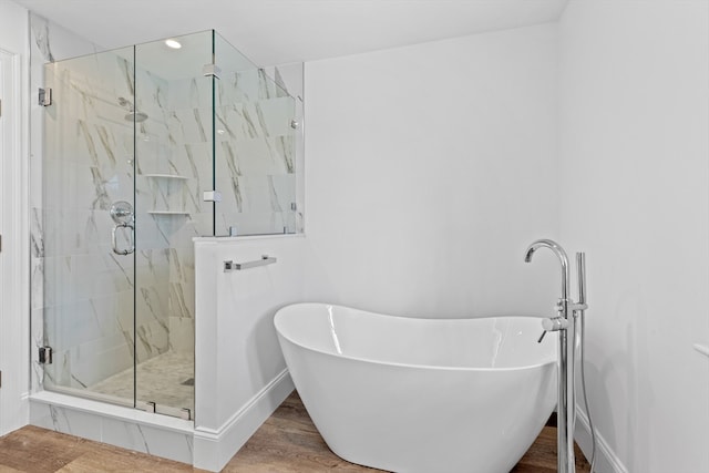 bathroom featuring hardwood / wood-style flooring and shower with separate bathtub