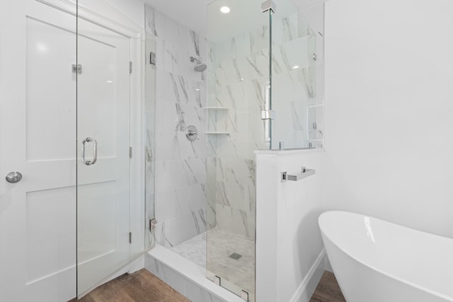 bathroom featuring plus walk in shower and wood-type flooring