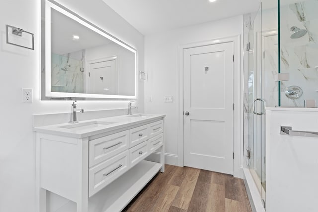 bathroom featuring vanity, wood-type flooring, and a shower with door