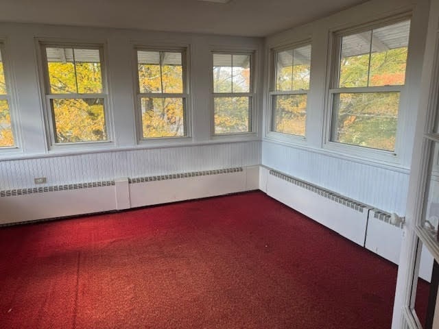 unfurnished sunroom featuring a baseboard radiator