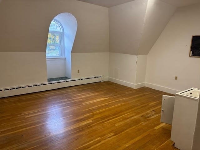 bonus room featuring wood-type flooring, vaulted ceiling, and a baseboard radiator