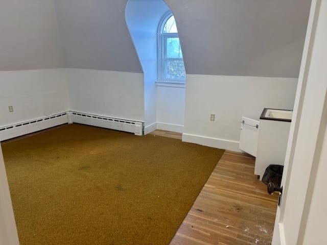 bonus room featuring lofted ceiling, hardwood / wood-style floors, and baseboard heating