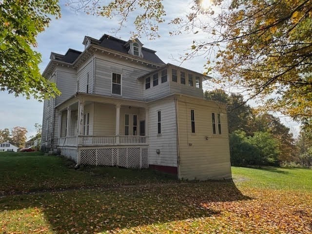 exterior space with a porch and a lawn