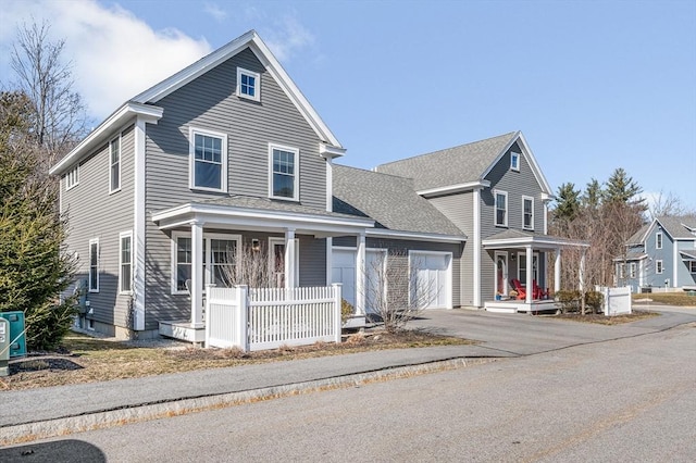 traditional-style home featuring a porch, an attached garage, driveway, and a shingled roof