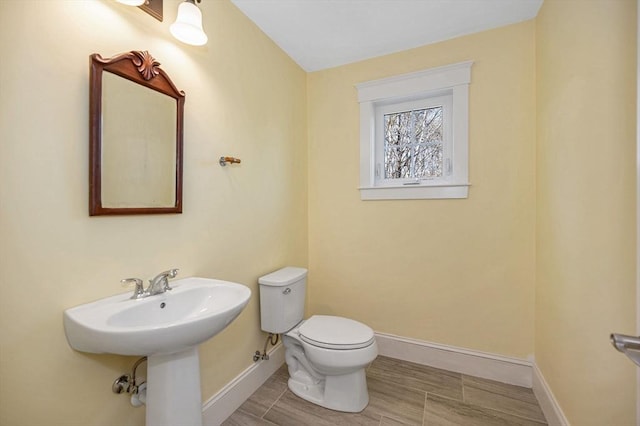 bathroom with baseboards and toilet