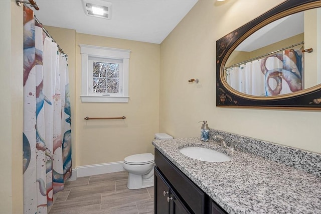 bathroom featuring visible vents, toilet, vanity, and baseboards