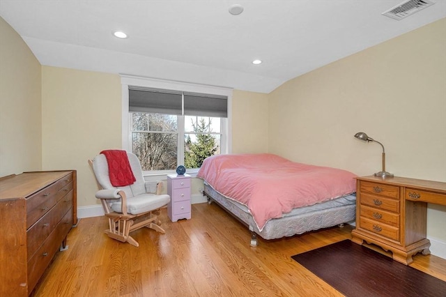 bedroom featuring visible vents, light wood-style flooring, recessed lighting, baseboards, and lofted ceiling