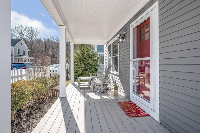 wooden deck featuring a porch and fence