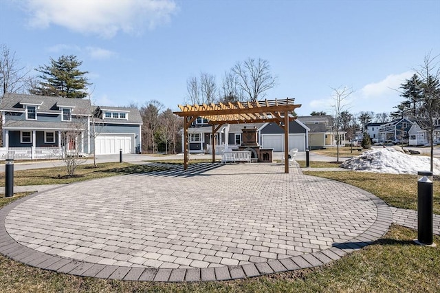 surrounding community with a garage, decorative driveway, a pergola, and a residential view