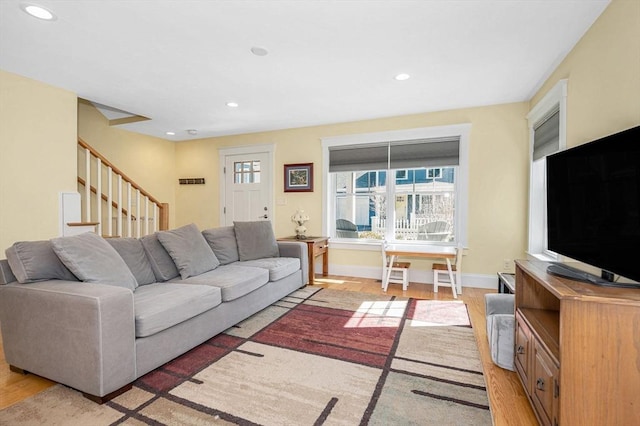 living area featuring recessed lighting, baseboards, stairs, and light wood-style floors