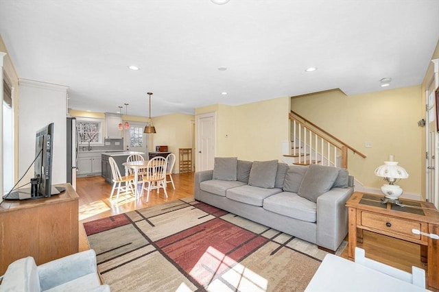 living room with recessed lighting, stairway, and light wood finished floors