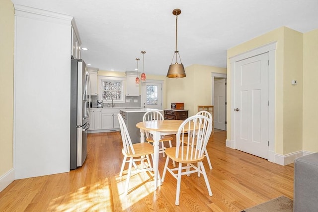 dining area with recessed lighting, baseboards, and light wood finished floors