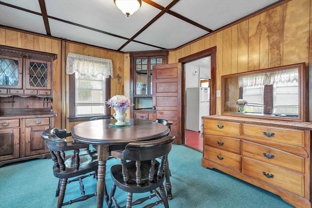 dining area with dark colored carpet and wooden walls