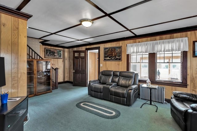 living room featuring radiator, wood walls, carpet, and stairway