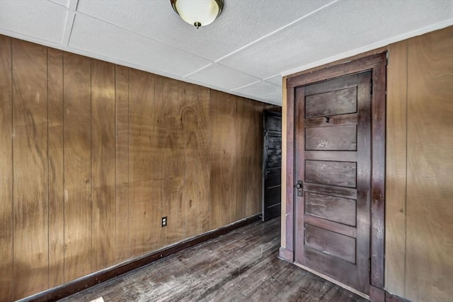 empty room with wooden walls and wood finished floors