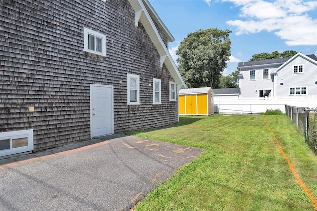 view of yard featuring a storage shed, an outdoor structure, and a fenced backyard