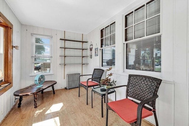 sitting room featuring radiator, light wood-style floors, and a sunroom