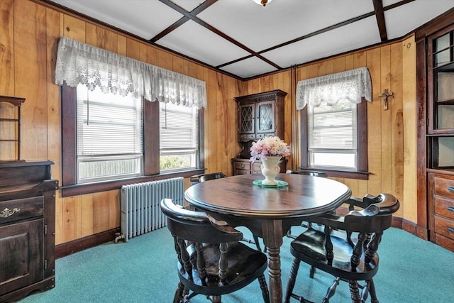 dining area with radiator, wood walls, and carpet