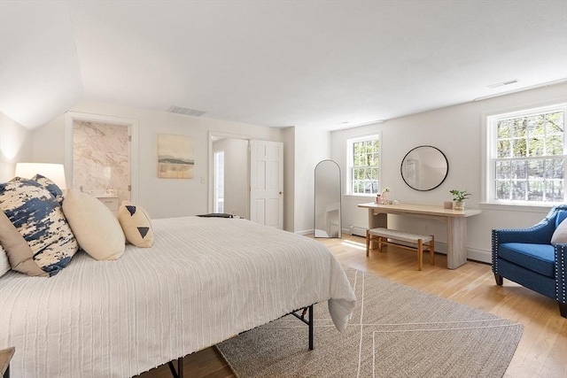 bedroom featuring visible vents, a baseboard radiator, and light wood-style floors