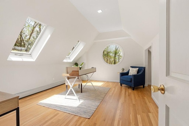 additional living space with vaulted ceiling with skylight, baseboards, baseboard heating, and light wood-style flooring