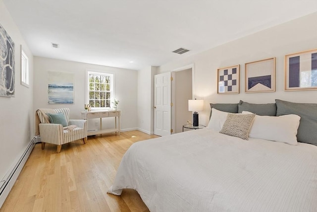 bedroom with visible vents, baseboards, a baseboard heating unit, and light wood-type flooring